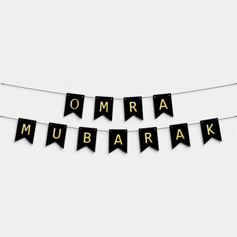 Bannière 'OMRA MUBARAK' de Galeries d'Orient, noir et or, pour célébrations.